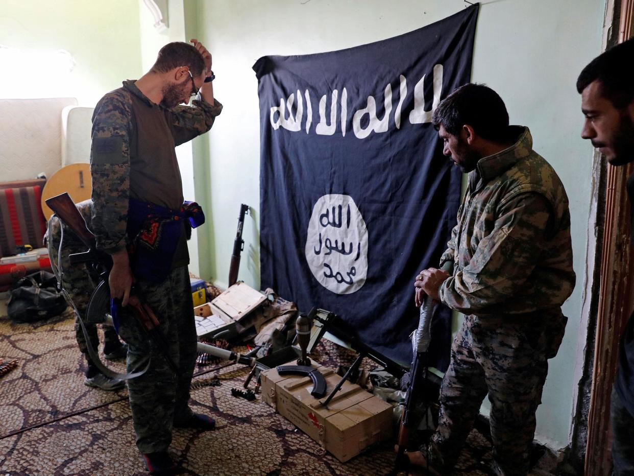 Fighters of Syrian Democratic Forces inspect weapons and munitions recovered at the former positions of the Isis militants inside a building at the frontline in Raqqa: Reuters