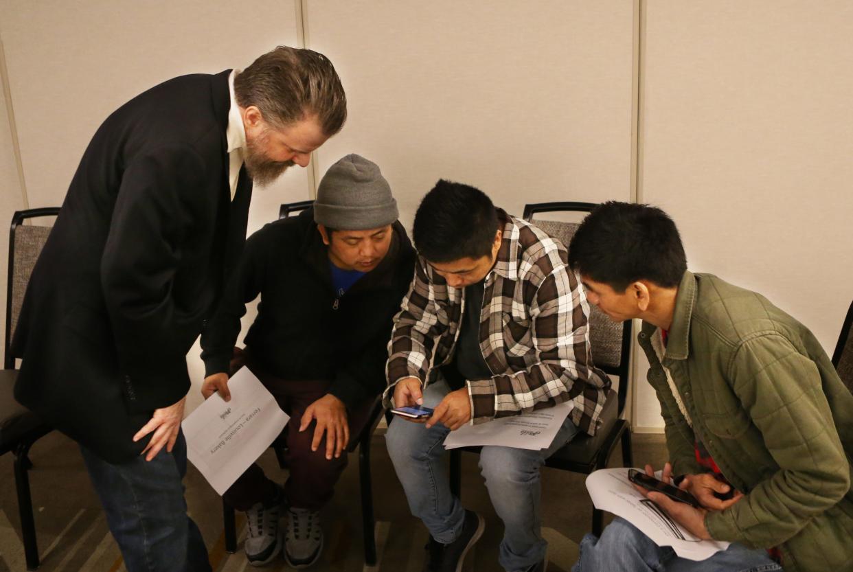 Jason Burwinkle, Human Resources manager for Ferrara Candy Company, helps three people fill out job applications Tuesday afternoon at a job fair at Best Western Premier Hotel.April 5, 2022