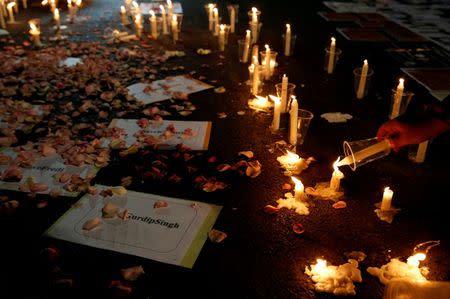 A protester holds a candle during a demonstration against Indonesia's decision to execute 14 drug convicts in front of the Presidential Palace in Jakarta, Indonesia, July 28, 2016. REUTERS/Beawiharta