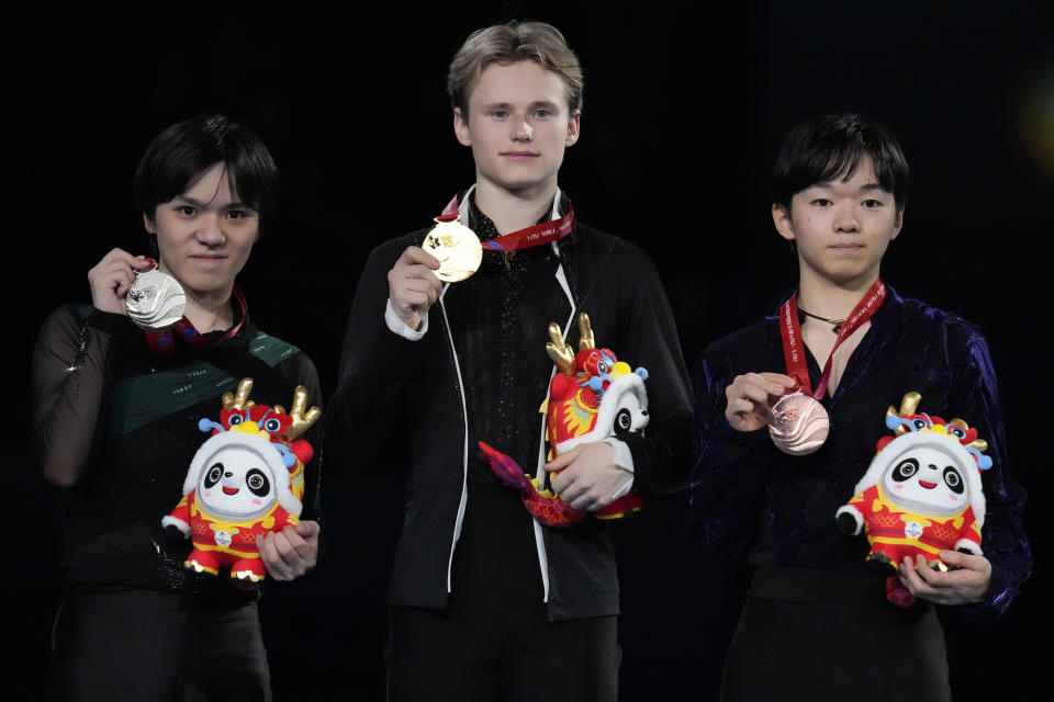 From left, silver medalist Japan's Shoma Uno, gold medalist United State's Ilia Malinin and bronze medalist Japan's Yuma Kagiyama pose for photos during the victory ceremony for the Men's Final in the ISU Grand Prix of Figure Skating Final held in Beijing, Saturday, Dec. 9, 2023. (AP Photo/Ng Han Guan)
