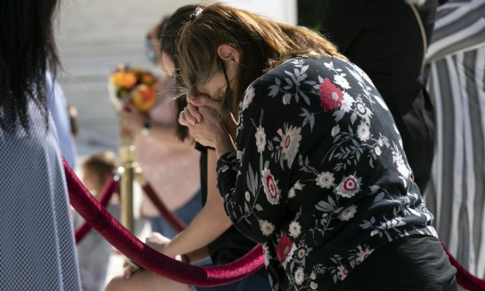 Mourners pray as they pay their respects.