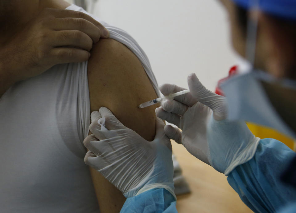 FILE - in this file photo dated Saturday, Jan. 30, 2021, a Moroccan nurse administers the Oxford AstraZeneca COVID-19 vaccine to a health worker, at Cheikh Khalifa Hospital in Casablanca, Morocco. The World Health Organization Monday Feb. 15, 2021, granted an emergency authorization to the coronavirus vaccine made by AstraZeneca, a move that should allow its partners to ship millions of doses to countries worldwide as part of a U.N.-backed program to stop the pandemic.(AP Photo/Abdeljalil Bounhar)