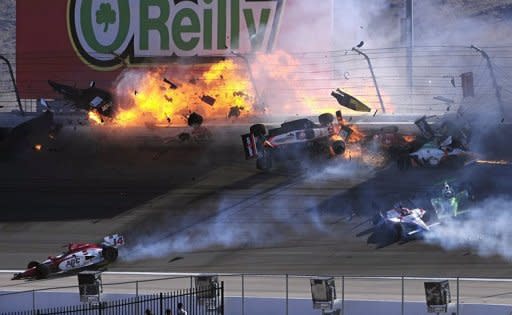 The car of Dan Wheldon (top L) bursts into flames in a 15 car pile up during the Las Vegas Indy 300. Wheldon was seriously hurt in a massive 15-car crash that sent several cars airborne early in the Las Vegas 300 IndyCar series finale