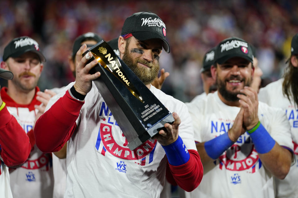 Philadelphia Phillies designated hitter Bryce Harper celebrates with the trophy after winning the baseball NL Championship Series in Game 5 against the San Diego Padres on Sunday, Oct. 23, 2022, in Philadelphia. (AP Photo/Matt Slocum)