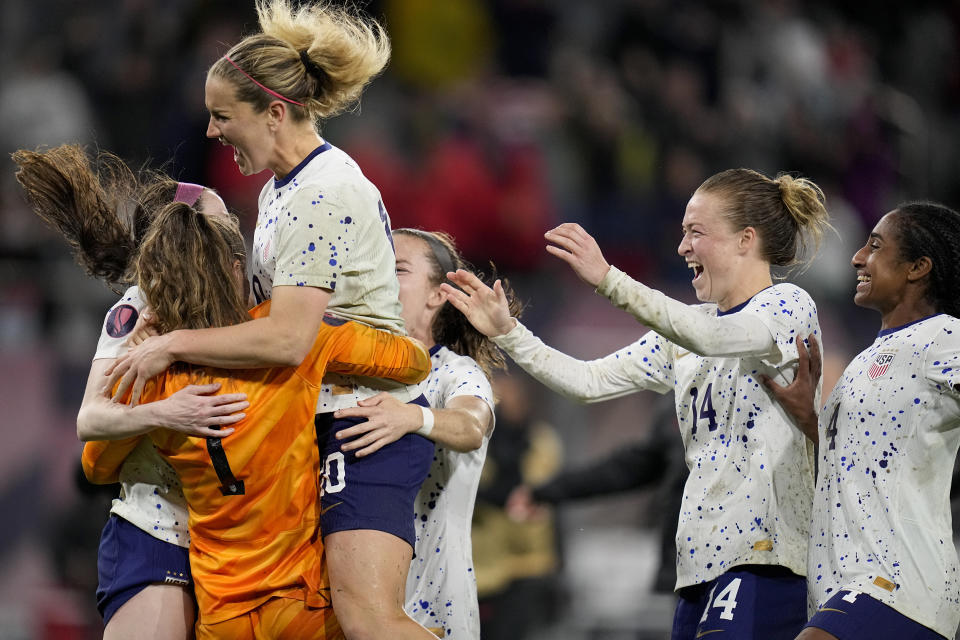 United States goalkeeper Alyssa Naeher, left in orange, celebrates with teammates at the end of the penalty shootout in a CONCACAF Gold Cup women's soccer tournament semifinal match against Canada, Wednesday, March 6, 2024, in San Diego. (AP Photo/Gregory Bull)