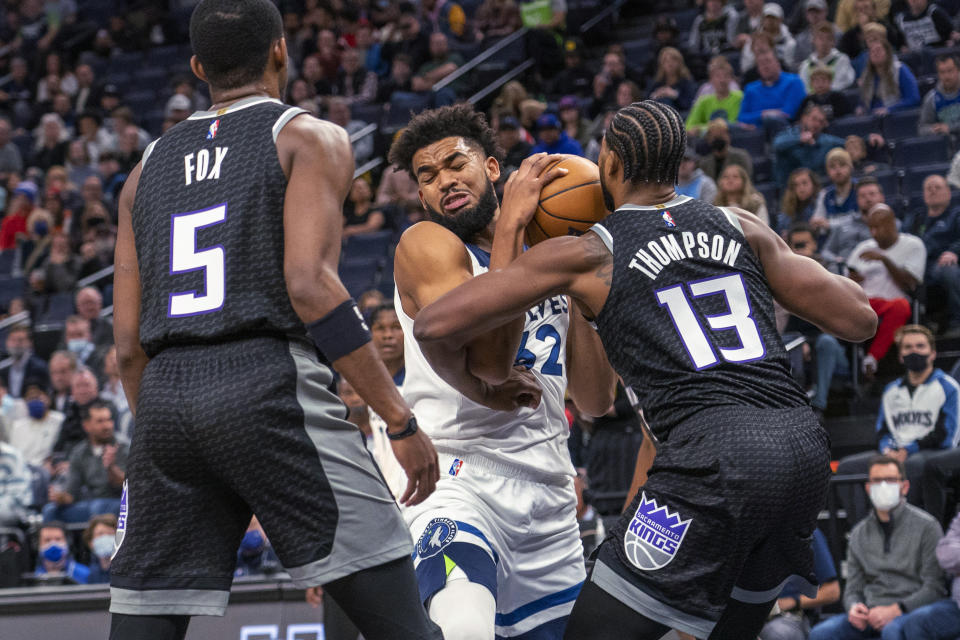 Minnesota Timberwolves center Karl-Anthony Towns, center, collides with Sacramento Kings center Tristan Thompson (13) as guard De'Aaron Fox watches during the first half of an NBA basketball game Wednesday, Nov. 17, 2021, in Minneapolis. (AP Photo/Craig Lassig)