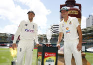 England captain Joe Root, left, and Australian captain Pat Cummins pose with the Ashes trophy at the Gabba cricket ground ahead of the first Ashes cricket test in Brisbane, Australia, Sunday, Dec. 5, 2021. (AP Photo/Tertius Pickard)