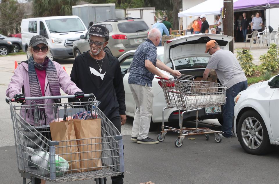 Volunteers push shopping carts loaded with Thanksgiving food donations to cars on Wednesday during the annual distribution event at the Jewish Federation of Volusia & Flagler Counties in Ormond Beach. This year's event offered meals to a record 300 families in need.