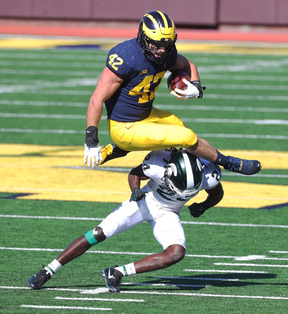 Michigan Wolverines tight end Ben Mason is tackled by Michigan State Spartans safety Tre Person during the second quarter at Michigan Stadium in Ann Arbor, Saturday, Oct. 31, 2020.