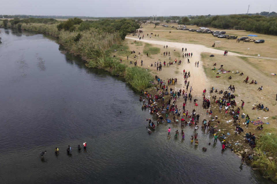 FILE - In this Sept. 21, 2021, file photo, migrants, many from Haiti, are seen wading between the U.S. and Mexico on the Rio Grande, in Del Rio, Texas. The Border Patrol's treatment of Haitian migrants, they say, is just the latest in a long history of discriminatory U.S. policies and of indignities faced by Black people, sparking new anger among Haitian Americans, Black immigrant advocates and civil rights leaders.(AP Photo/Julio Cortez, File)