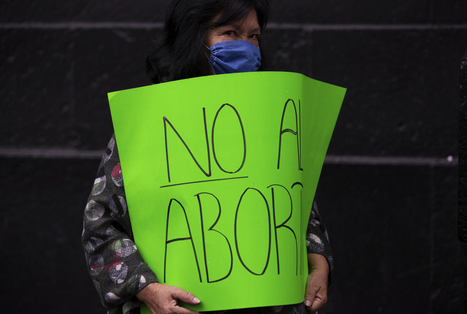 An activist holds a poster that reads in Spanish "No to abortion" outside the Supreme Court which ruled against an injunction in Veracruz state that aimed to decriminalize abortion for all cases within the first 12 weeks of pregnancy, in Mexico City, Wednesday, July 29, 2020. Two of Mexico’s 32 states have decriminalized abortion. (AP Photo/Fernando Llano)