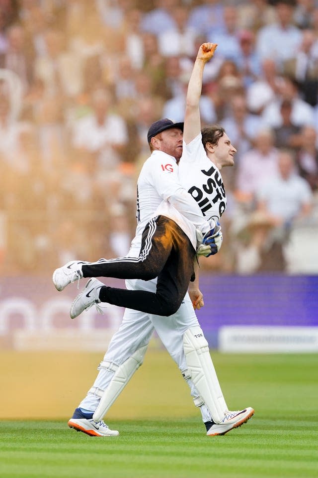 Jonny Bairstow carries a protester off the pitch