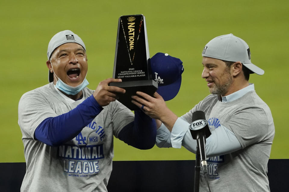 Los Angeles Dodgers manager Dave Roberts, left, and President of Baseball Operations Andrew Friedman celebrate with the trophy after winning Game 7 of a baseball National League Championship Series against the Atlanta Braves Sunday, Oct. 18, 2020, in Arlington, Texas. (AP Photo/Eric Gay)