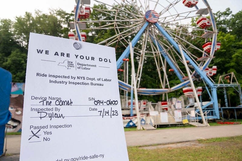 A sign displays a white New York Department of Labor inspection tag for carnival rides at the Saratoga County Fair on July 18, 2023.