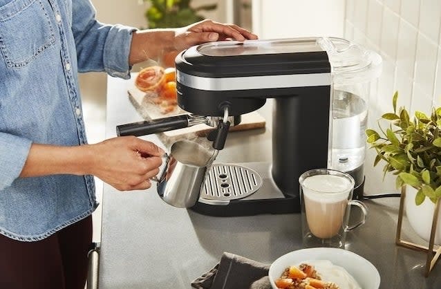 a person making an espresso and using the steam wand