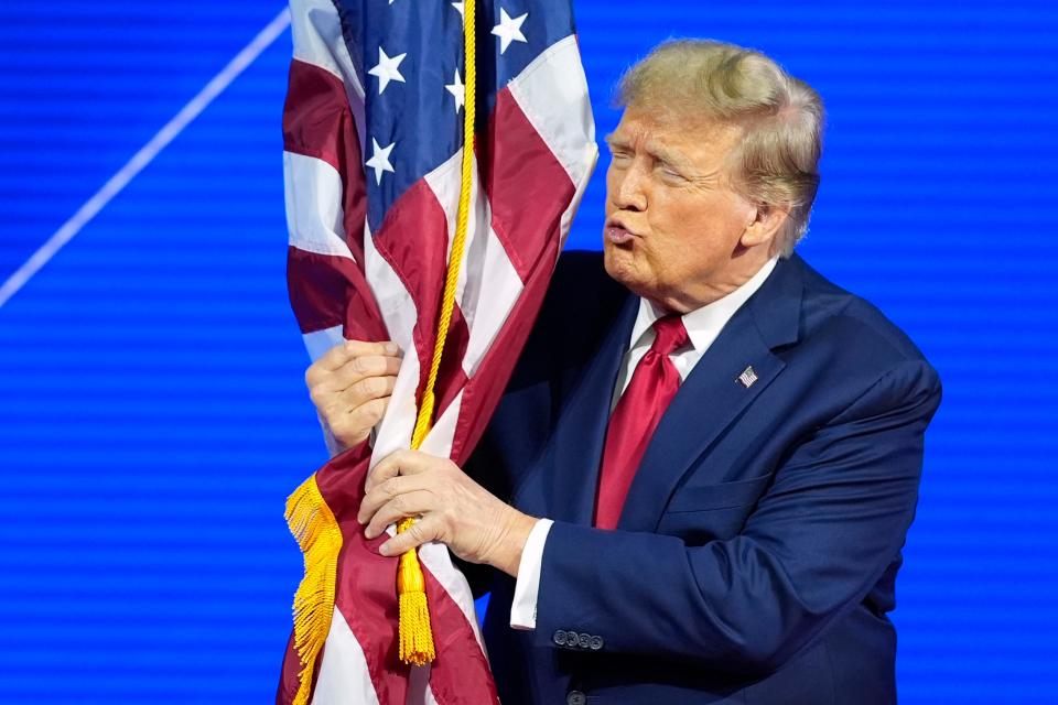 Republican presidential candidate former President Donald Trump hugs and kisses the American flag as he speaks at the Conservative Political Action Conference, CPAC 2024, at National Harbor, in Oxon Hill, Md., Saturday, Feb. 24, 2024. (AP Photo/Alex Brandon)