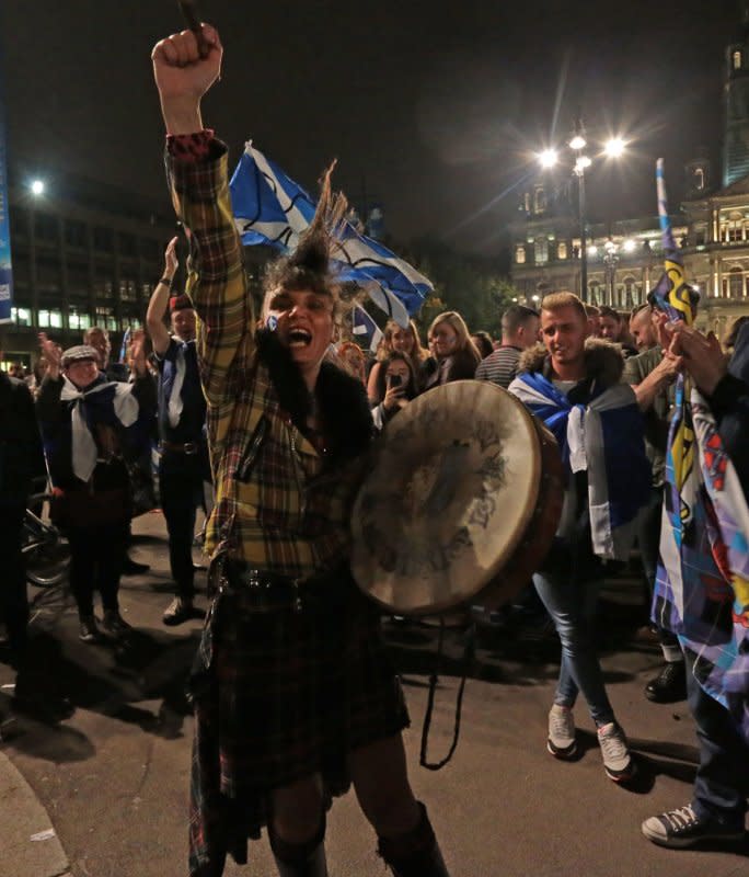 "Yes" campaigners carry flags on the day Scottish residents decide the future political direction their country will take in Glasgow, Scotland, on September 18, 2014. File Photo by Hugo Philpott/UPI