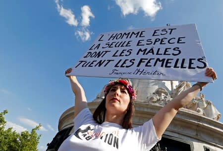 A woman holds a banner as families of victims and activists attend a rally against "femicide", gender-based violence targeted at women, in Paris