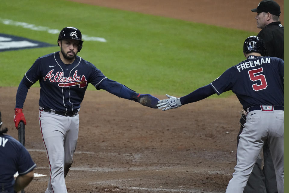 Atlanta Braves' Travis d'Arnaud celebrates after scoring on a ball hit by Jorge Soler during the second inning of Game 1 in baseball's World Series between the Houston Astros and the Atlanta Braves Tuesday, Oct. 26, 2021, in Houston. (AP Photo/Eric Gay)