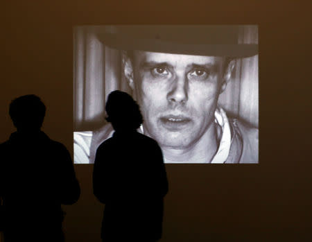 FILE PHOTO: Visitors stand in front of the screen projecting videos of artist Joseph Beuys during the exhibition 'Beuys, We are the Revolution' at the The Hamburger Bahnhof museum for contemporary arts in Berlin October 1, 2008. REUTERS/Pawel Kopczynski/File Photo