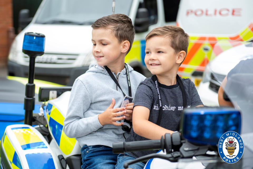 Young and blind Oscar Jealous aged 8 (left) on his dream day getting a special tour of West Midlands Polices Bournville station with his brother Charlie. See SWNS story SWMDwish. A young boy who lost his sight due to a rare life-limiting disease enjoyed a "dream day" by becoming an honorary police officer, ticking off one of the items on his bucket list. Oscar Jealous, 8, from Kingstanding, Birmingham, recently spent the day with West Midlands Police at Bournville station. The youngster, who suffers from the degenerative Batten disease, went behind the wheel of a police car, played custody sergeant in the cell blocks and cuddled the new puppy recruits. He and his younger brother Charlie were also given warrant cards as a memento.