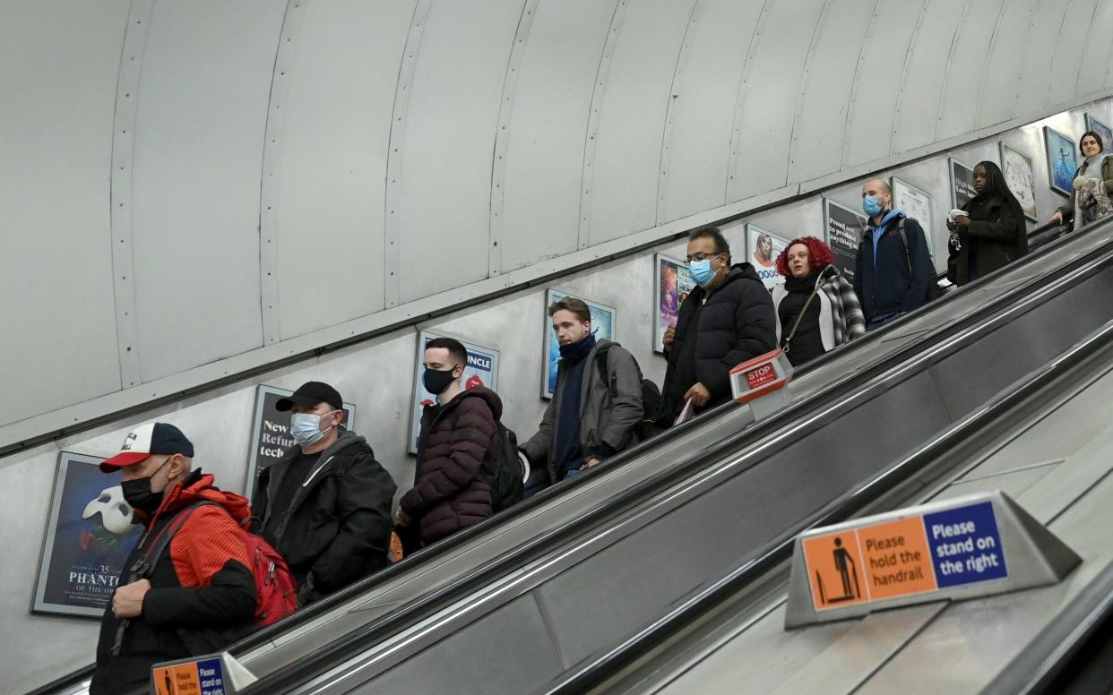 Commuters wear protective facemasks as they arrive at Stratford station in November - Anadolu 