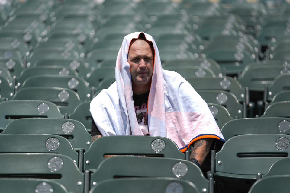 Greg Cobb, of Chicago, wears a towel on his head in the hot weather before a baseball game between the Detroit Tigers and Chicago White Sox, Saturday, June 22, 2024, in Detroit. (AP Photo/Paul Sancya)