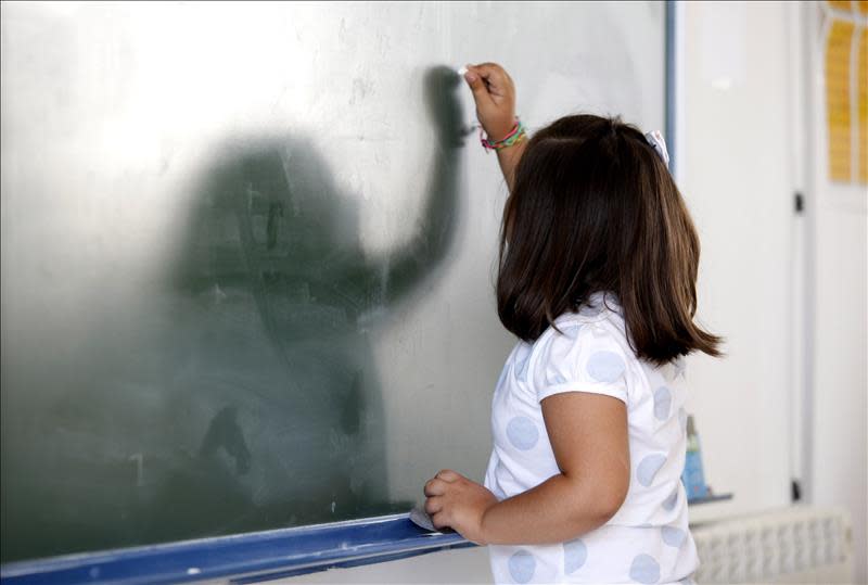 Una niña escribe en una pizarra. EFE/Archivo