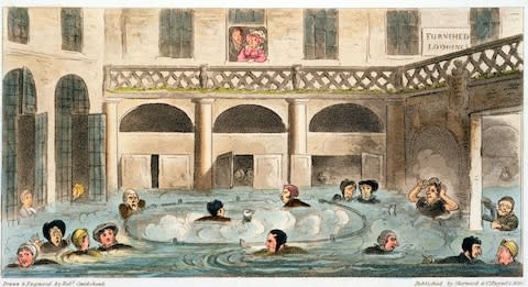 1825: Bathers taking the waters or 'stewing' in the Roman baths at Bath in Somerset, wearing clothes and even hats to preserve their modesty. - Credit: GETTY