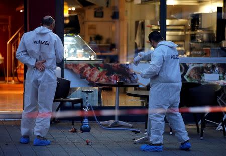 Police forensic experts work outside where a 21-year-old Syrian refugee killed a woman with a machete and injured two other people in the city of Reutlingen, Germany July 24, 2016. REUTERS/Vincent Kessler