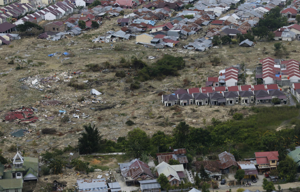 This Sunday, Oct. 7, 2018, aerial photo covers a part of the Petobo neighborhood wiped out by earthquake-triggered liquefaction in Palu, Central Sulawesi, Indonesia. All that remains of the village, located about 30 minutes from the city center, is a muddy wasteland where only the very tips of roofs remain above ground in some places. Satellite images show a heavily populated area stretching more than 100 hectares (250 acres) being devoured by what looks like a giant layer of chocolate milk. (AP Photo/Dita Alangkara)