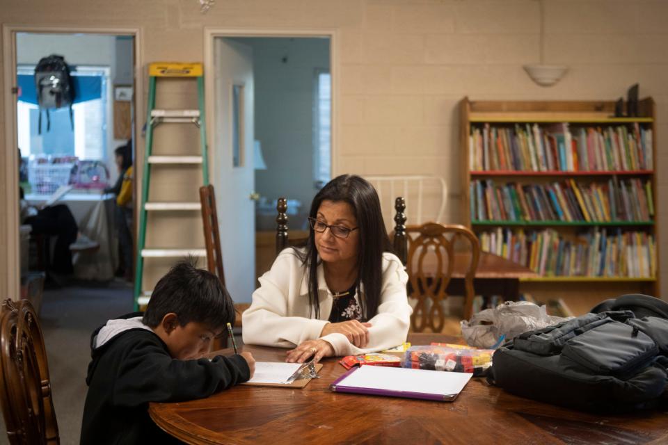 Thrive Lonsdale volunteer Liliana Gallego helps a student with their homework.