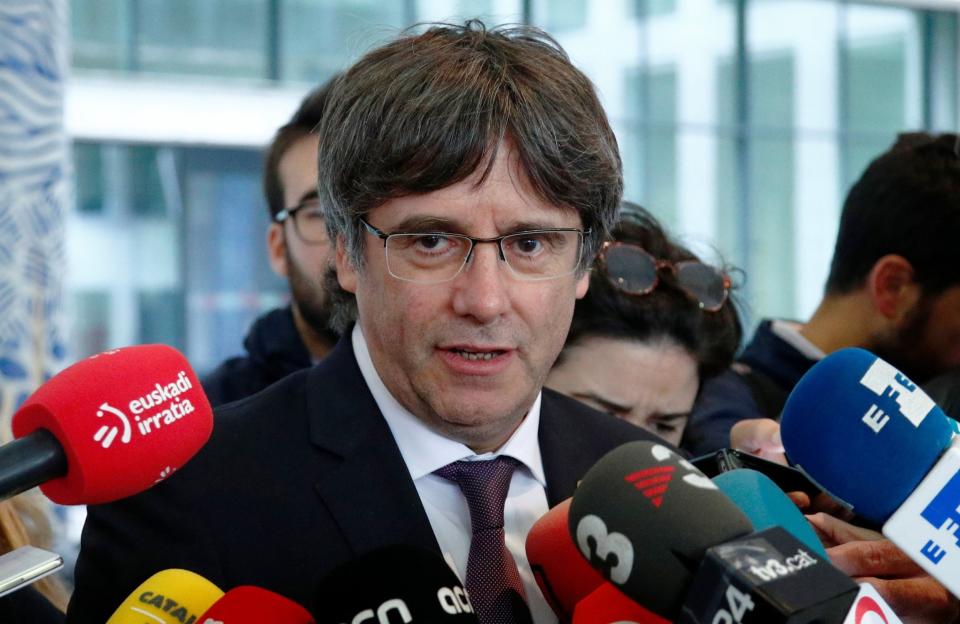 Former Catalan leader Carles Puigdemont talks to the media as he leaves free a prosecutor office at the Justice Palace after handing himself to police in Brussels: REUTERS