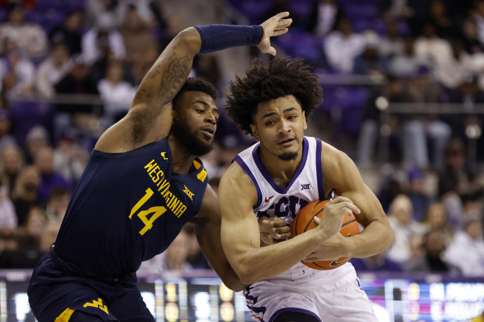 TCU guard Micah Peavy, right, breaks to the basket as West Virginia guard Seth Wilson (14) defends in the first half of an NCAA college basketball game, Tuesday, Jan. 31, 2023, in Fort Worth, Texas. (AP Photo/Ron Jenkins)