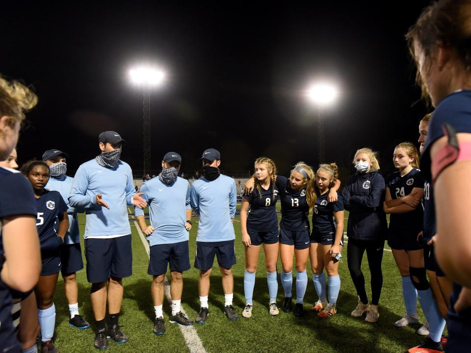 Coach Scott Forster (left center) talks to his players after they pulled out a 3-2 overtime win against Monroe in the 2020 Division II regional semifinals, reaching their third state title game.