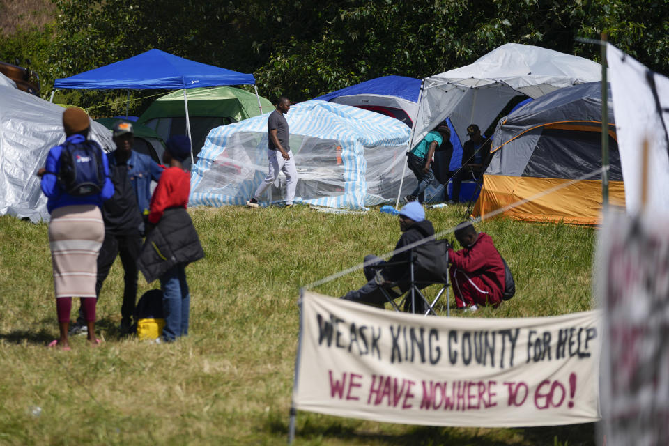 A man walks through an encampment of asylum-seekers mostly from Venezuela, Congo and Angola next to an unused motel owned by the county, Wednesday, June 5, 2024, in Kent, Washington. The group of about 240 asylum-seekers is asking to use the motel as temporary housing while they look for jobs and longer-term accommodations. (AP Photo/Lindsey Wasson)