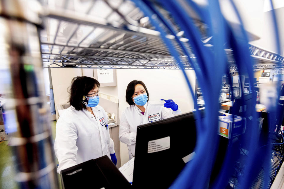 Marilyn Mar, right, and Nai-Hua Jeng process upper respiratory samples from patients suspected of having COVID-19 at the Stanford Clinical Virology Laboratory on Wednesday, Feb. 3, 2021, in Palo Alto, Calif. Viruses mutate constantly. To stay ahead of the threat, scientists analyze samples for genetic changes, watching closely for ones that might make the virus more infectious or more deadly. (AP Photo/Noah Berger)