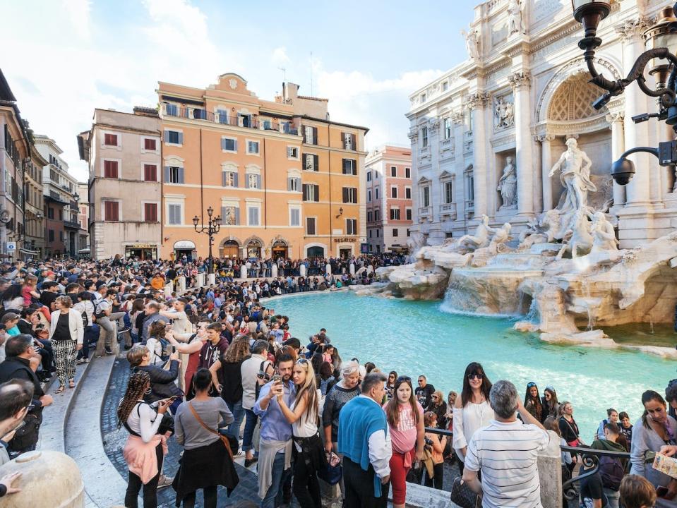 Tourists visit the Trevi Fountain in Rome, Italy.