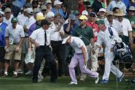 Luke Donald of Britain is helped back onto the course by a security guard after having to chip from the crowd on the second hole during second round play of the Masters golf tournament at the Augusta National Golf Course in Augusta, Georgia April 10, 2015. REUTERS/Phil Noble