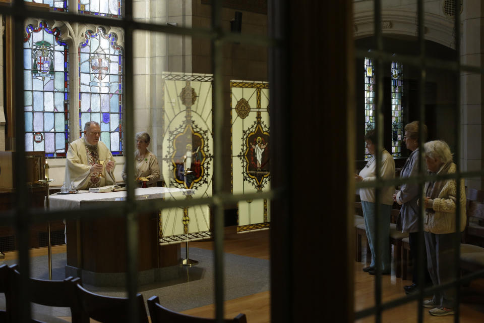 In this Thursday, Oct. 31, 2019 photo, Rev. Mark Stelzer, left, a professor and chaplain at College of Our Lady of the Elms, offers Mass in the school's chapel in Chicopee, Mass. Stelzer is also administrator of St. Jerome's Parish, in Holyoke, Mass., where he lives alone in a rectory while serving as spiritual leader to the 500 families of the Catholic parish. (AP Photo/Steven Senne)