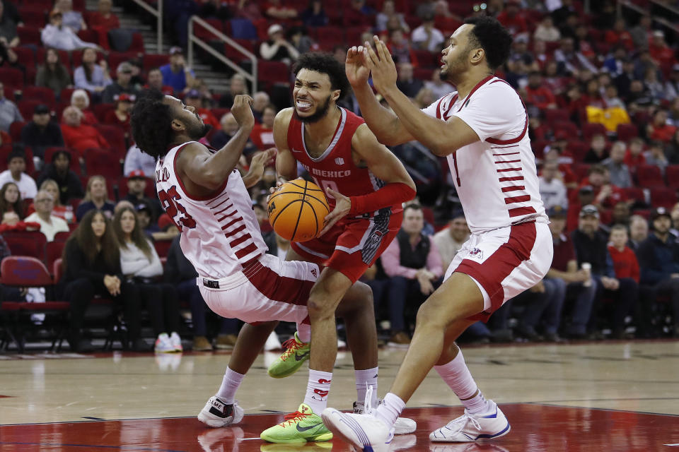 New Mexico's Jaelen House drives between Fresno State's Anthony Halland, left, and Jemarl Baker during the second half of an NCAA college basketball game in Fresno, Calif., Tuesday, Jan. 3, 2023. (AP Photo/Gary Kazanjian)