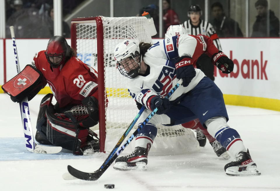 United States forward Kelly Pannek (12) tries the wrap-a-round on Switzerland goaltender Saskia Maurer (29) during the first period of a match at the Women's World Hockey Championships in Brampton, Ontario, Friday, April 7, 2023. (Nathan Denette/The Canadian Press via AP)