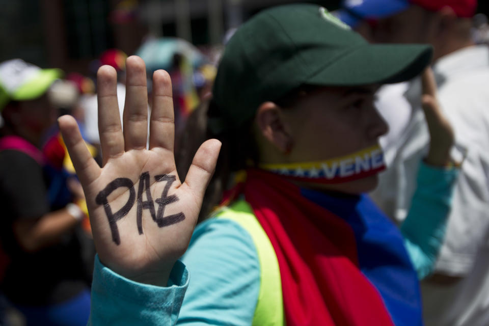 An anti-government demonstrator shows her hand with the word 'Peace' written in Spanish on it, before clashes broke out between the Bolivarian National Police and the demonstrators at the Central University of Venezuela, UCV, in Caracas, Venezuela, Thursday, March 20, 2014. Thursday dawned with two more opposition politicians, San Cristobal Mayor Daniel Ceballos and San Diego Mayor Enzo Scarano, behind bars. Police used tear gas and water cannons to disperse a student-called protest of several thousand people in Caracas, some of those demonstrating against the arrests of the mayors. (AP Photo/Esteban Felix