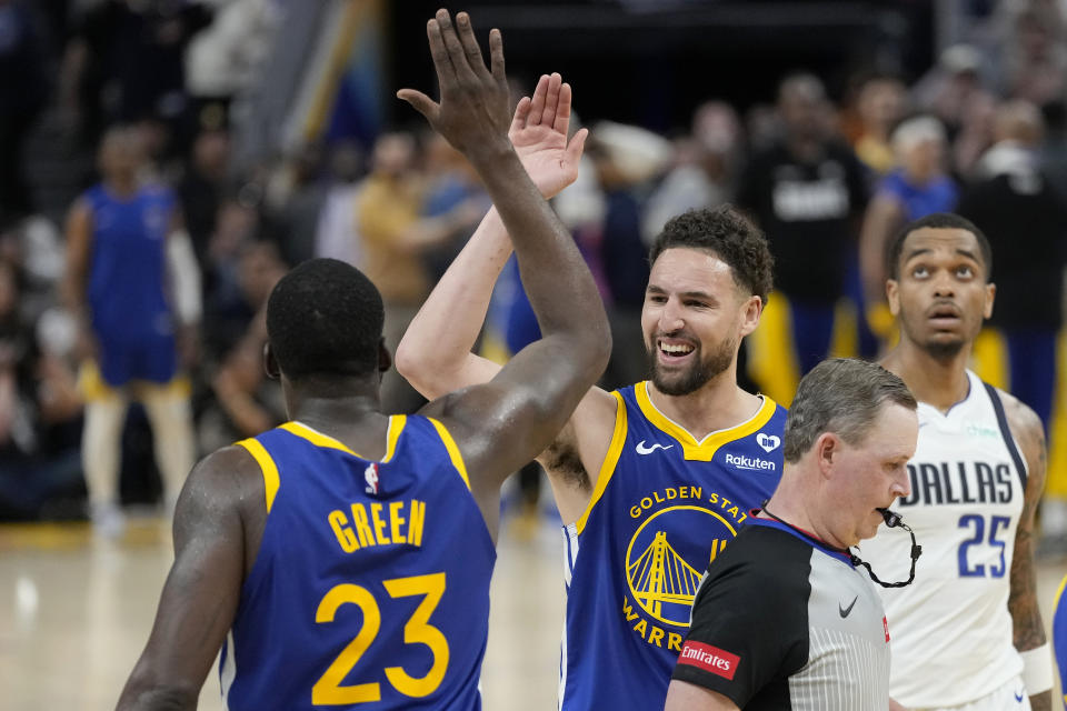 Golden State Warriors forward Draymond Green (23) celebrates with guard Klay Thompson during the second half of the team's NBA basketball game against the Dallas Mavericks in San Francisco, Tuesday, April 2, 2024. (AP Photo/Jeff Chiu)