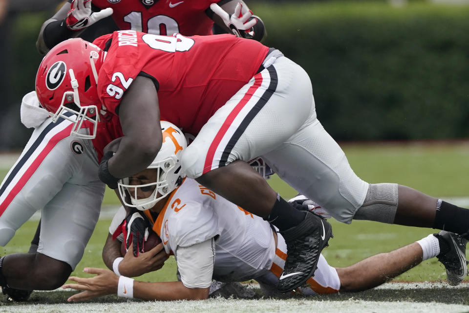 Tennessee quarterback Jarrett Guarantano (2) is brought down by Georgia defensive lineman Julian Rochester (92) after a short run in the first half of an NCAA college football game Saturday, Oct. 10, 2020, in Athens, Ga. (AP Photo/John Bazemore)