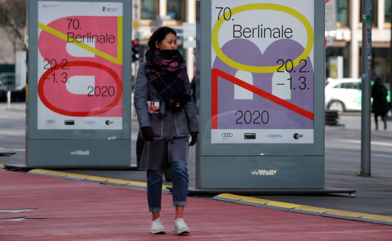 A pedestrian walks past an advertising billboard for the upcoming 70th Berlinale International Film Festival in Berlin