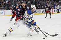 Buffalo Sabres' Tage Thompson, right, keeps the puck away from Columbus Blue Jackets' Gavin Bayreuther during the third period of an NHL hockey game Wednesday, Dec. 7, 2022, in Columbus, Ohio. (AP Photo/Jay LaPrete)