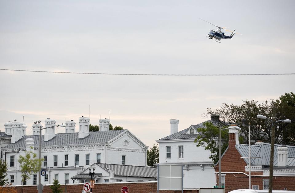 A police helicopter flies over the Washington Navy Yard as police respond to a shooting, in Washington September 16, 2013. A gunman shot five people at the U.S. Navy Yard on Monday, including two law enforcement officers, and the shooter was being sought in a building housing the Naval Sea Systems Command headquarters, officials said. (REUTERS/Joshua Roberts)