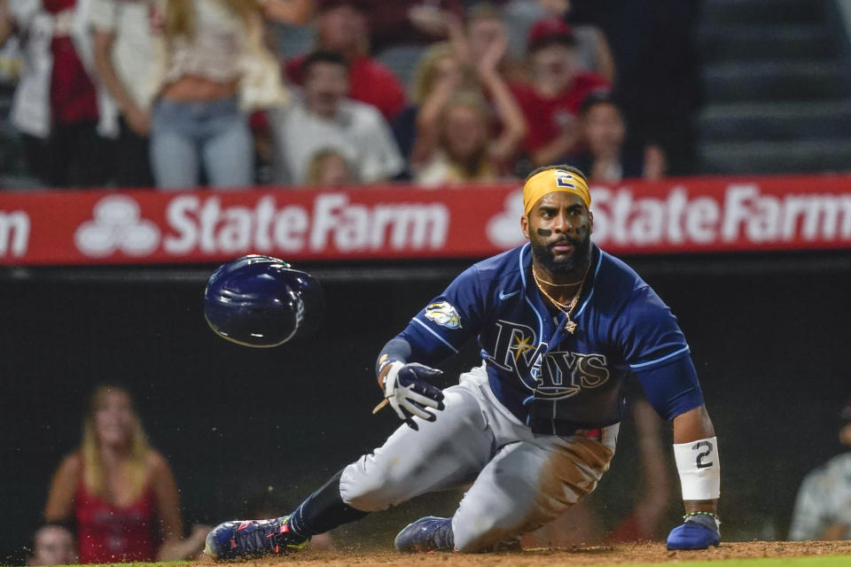 Tampa Bay Rays' Yandy Diaz loses his helmet after being tagged out at home by Los Angeles Angels catcher Logan O'Hoppe to complete a triple play started when Harold Ramirez grounded to short during the ninth inning of a baseball game Friday, Aug. 18, 2023, in Anaheim, Calif. Randy Arozarena was out at second and Ramirez out at first. (AP Photo/Ryan Sun)