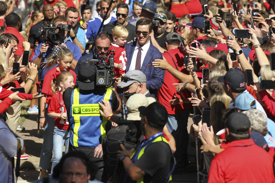 Former Mississippi quarterback Eli Manning Eli Manning leads the team through The Grove during the traditional "Walk of Champions" in Oxford, Miss., Saturday, Oct. 23, 2021. The school will retire his number during a halftime ceremony of an NCAA college football game against LSU. (Thomas Wells/The Northeast Mississippi Daily Journal via AP)